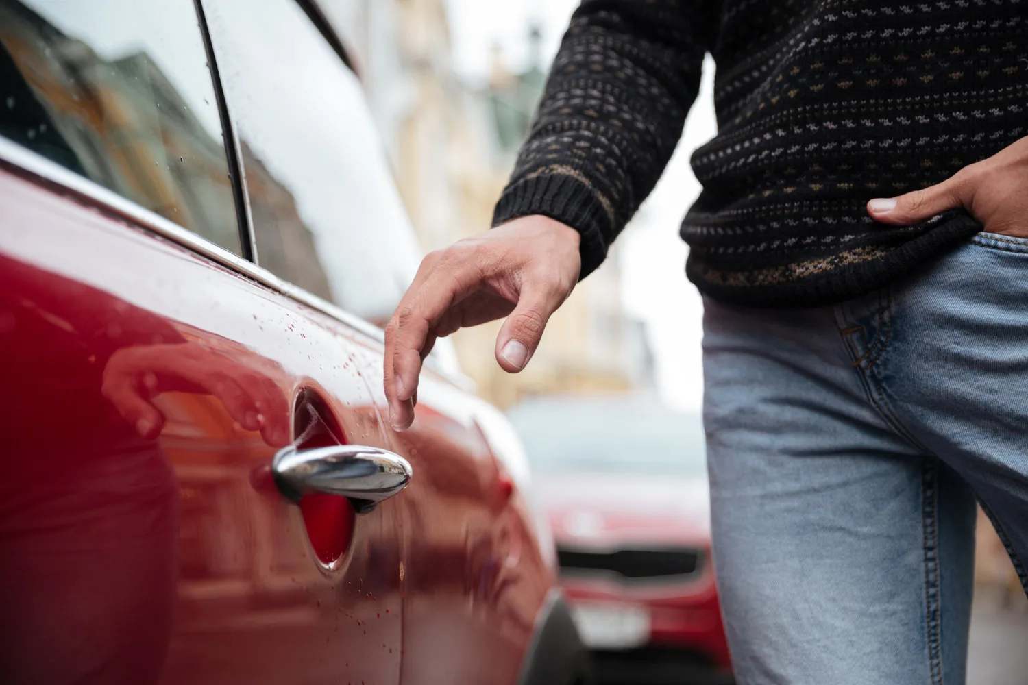 Hand reaching for car door handle during open trunk service — Alpha Brothers Towing Sacramento