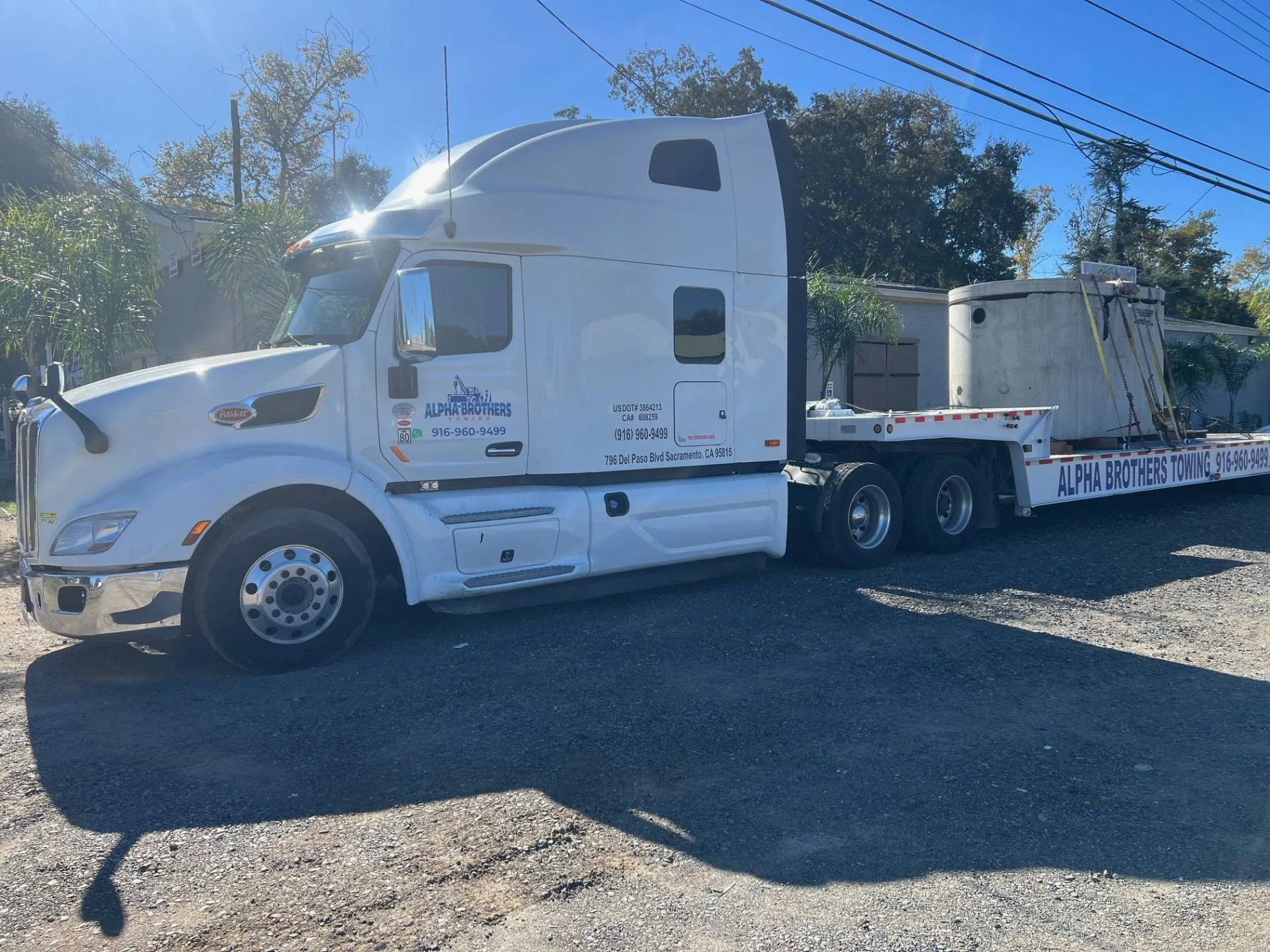 Alpha Brothers Peterbilt with lowboy trailer hauling a concrete vault in Sacramento